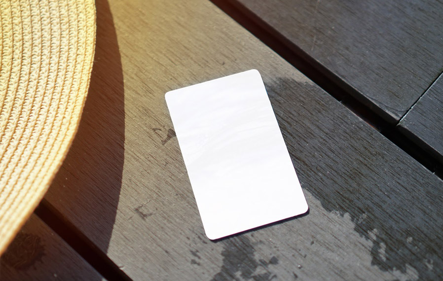 Don't forget your pool pass to to take a refreshing swim at City Flats at Renwick. Summer hat and key card on a deck floor.
